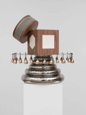 Ein Objekt aus runden und eckigen Elementen aus Holz und Metall mit Glocken.