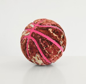 Ein Basketball, der mit bunten Teppichfragmenten beklebt ist.